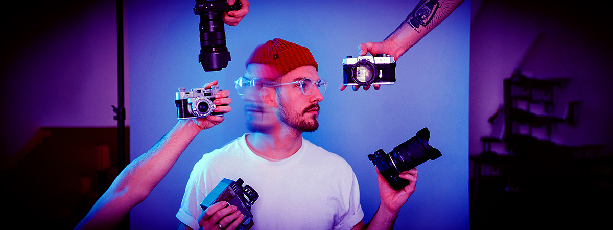 A man holding up two cameras, emphasizing the importance of personal brand assets for career growth and industry recognition.